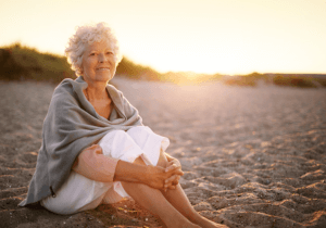 Alte Frau am Strand Schmerztherapie